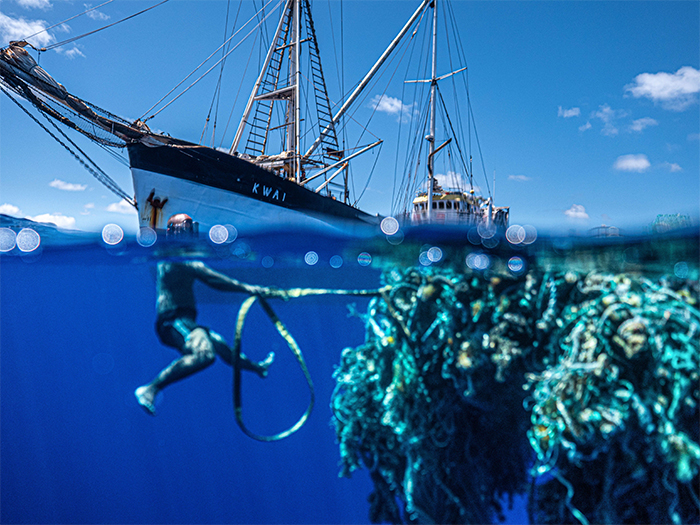 diver pulls a mass of ocean plastic