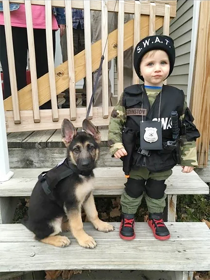 child and dog dressed as swat members