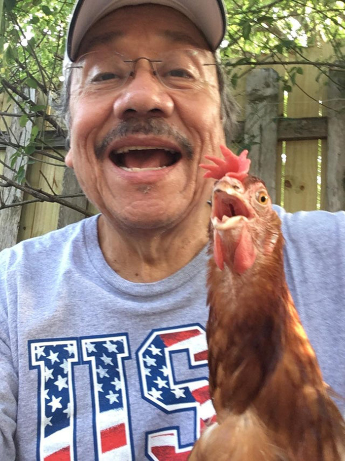 man taking a selfie with rooster