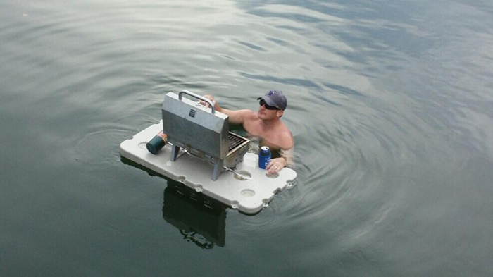 man with a bbq grill on floating bar