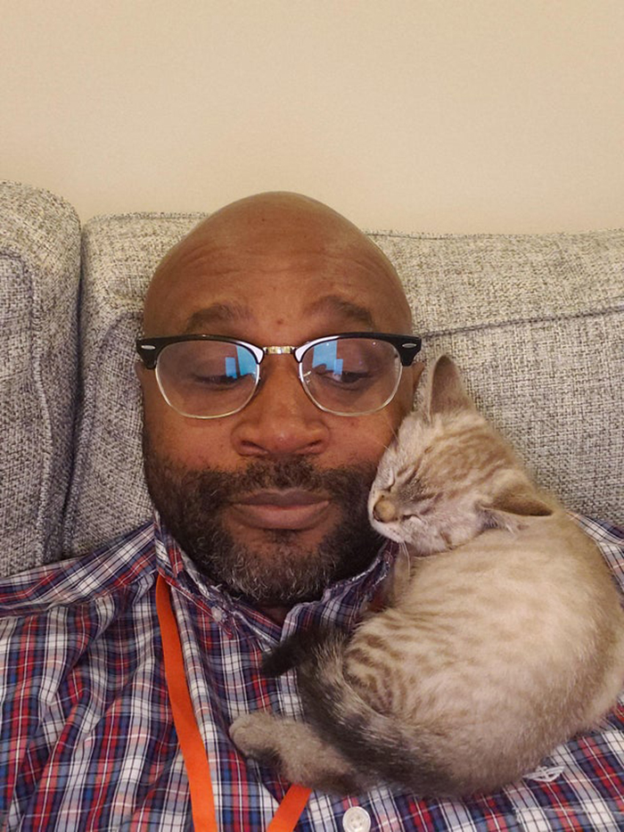 wholesome cat posts cat sleeping on a man's shoulder