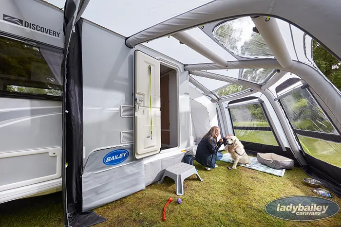 lady and a dog under an rv inflatable awning