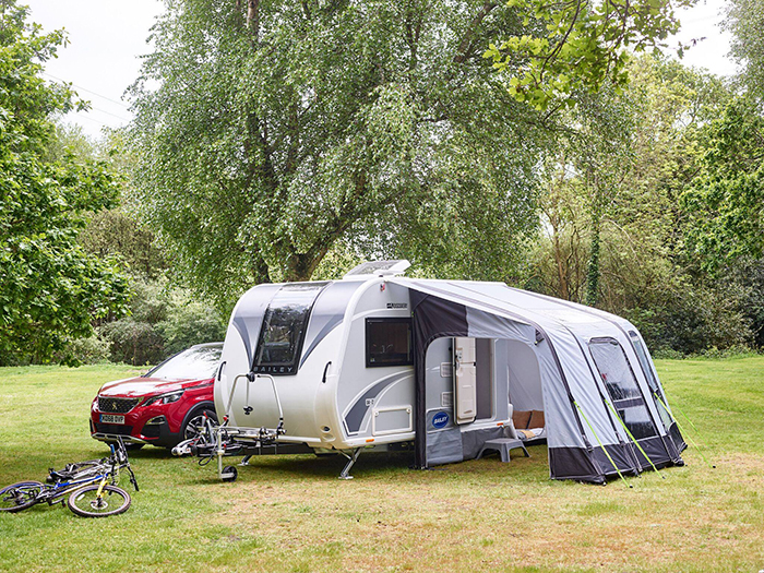 red car and bicycle parked beside an rv