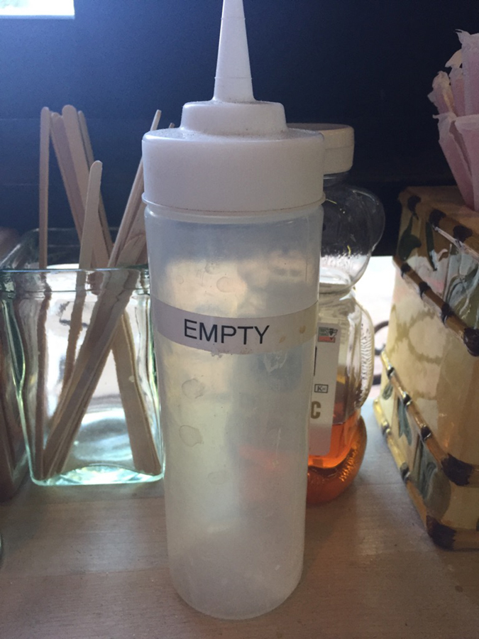 sarcastic coffee shop employee labels empty bottle to comply with health worker