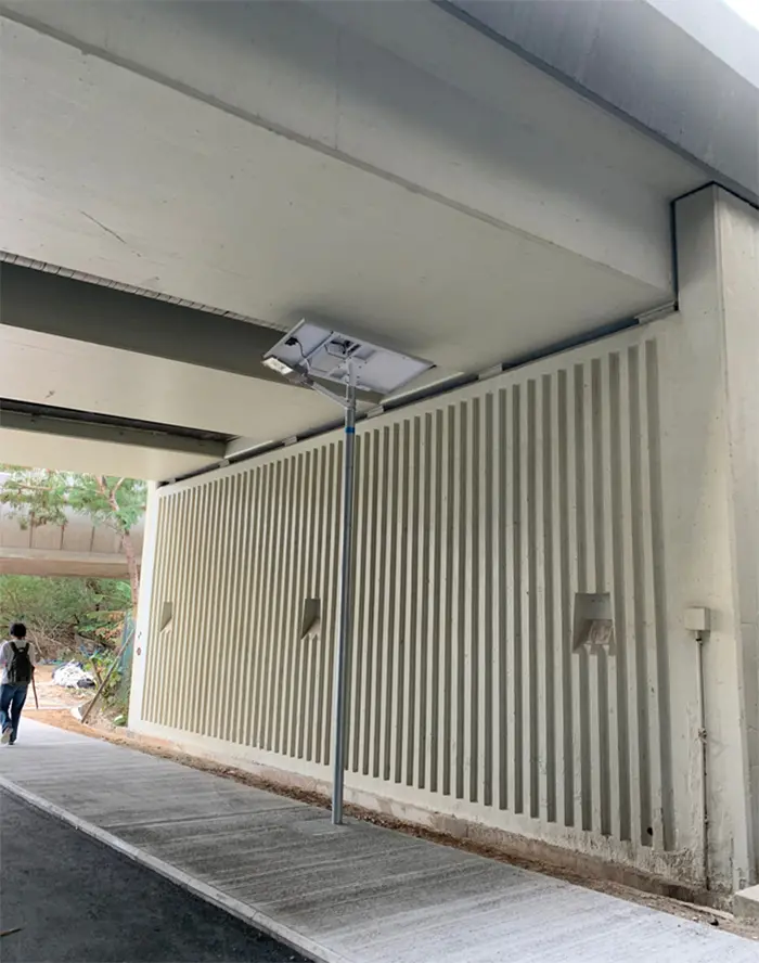 solar-powered streetlight under a bridge