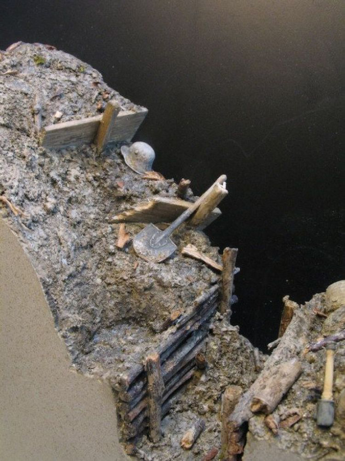 a miniature shovel placed atop a wwi trench warfare model by andy belsey