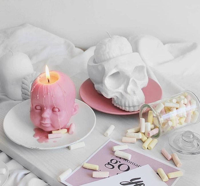 pink baby head candle and cranium-inspired candle holder