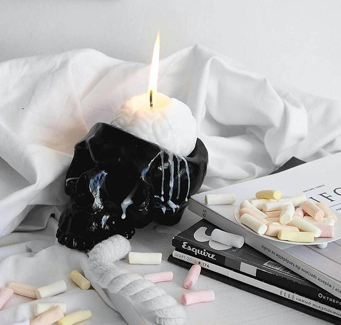 white human brain candle in black skull holder