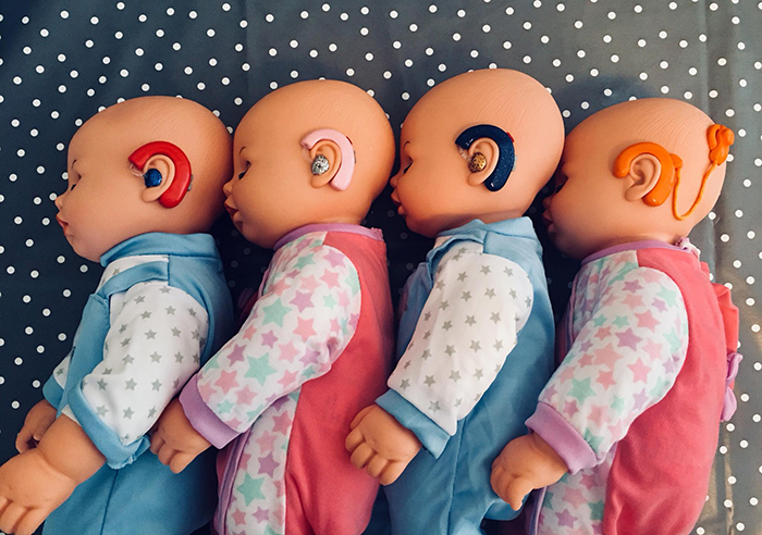 four baby dolls with hearing aids