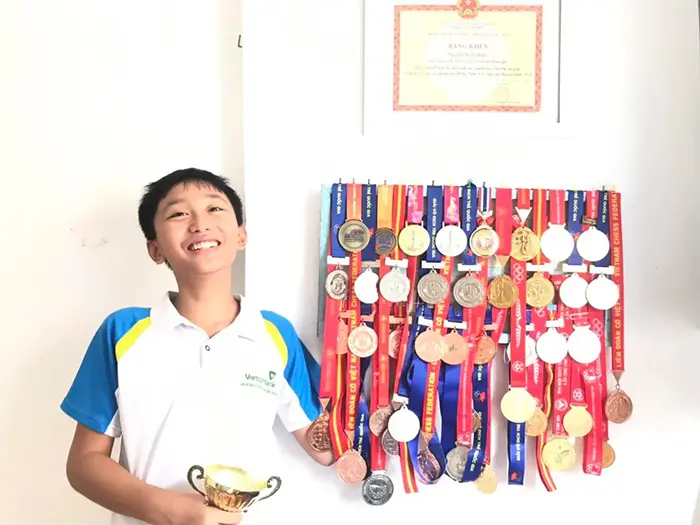 kid flexes chess medals