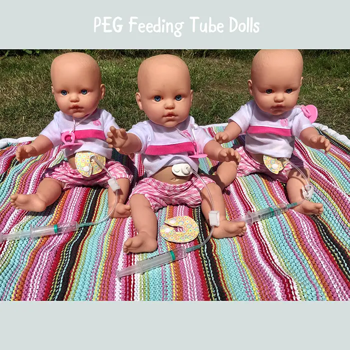 three baby dolls with percutaneous endoscopic gastrostomy feeding tubes