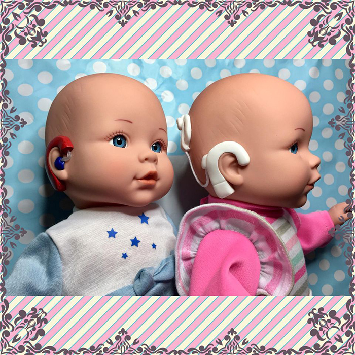 two baby dolls with hearing aids