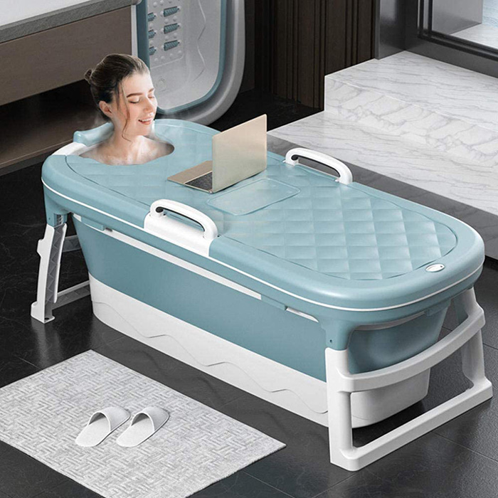 lady soaked in portable folding bathtub while working on laptop