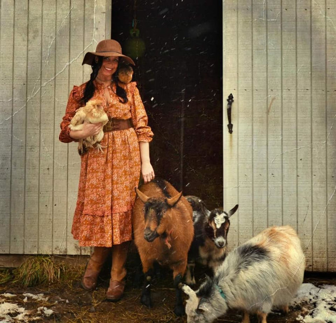 a woman grins as she poses alongside farm animals in her roasting entry