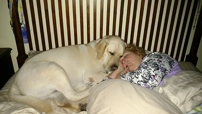 dog sleeping on bed beside owner's wife