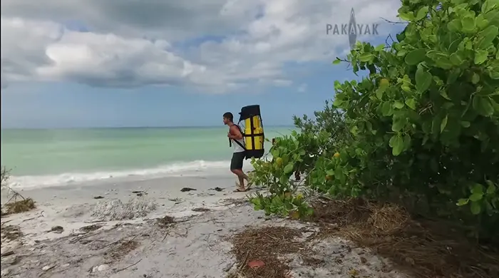man bringing pakayak portable kayak to the beach