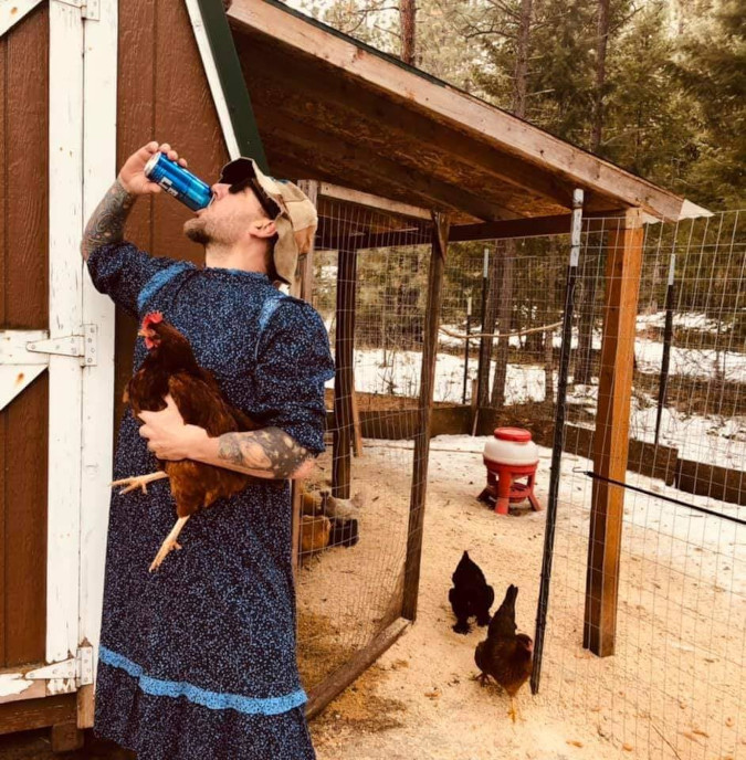 man chugs a drink and holds a fat hen while roasting target