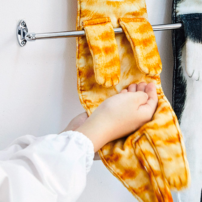 person dries hands using the orange tabby cat shaped towel