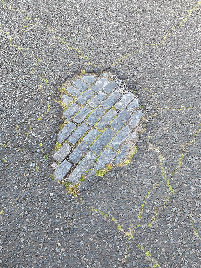 eroding road exposes old cobblestone