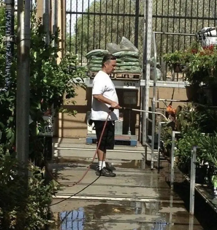 old people being wholesome man watering plants in walmart's garden section