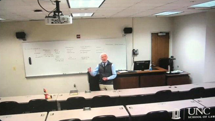 old people being wholesome professor conducting online class with pinocchio doll