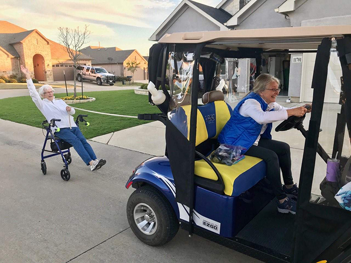 old people being wholesome women in retirement community driving golf cart