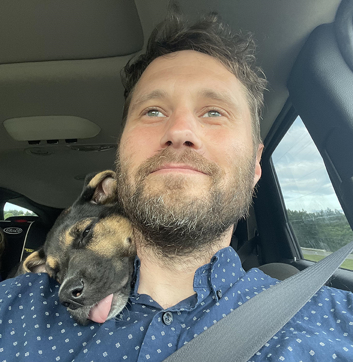 dorky pup leaning on owner's back