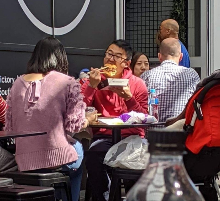 eating burger using chopsticks