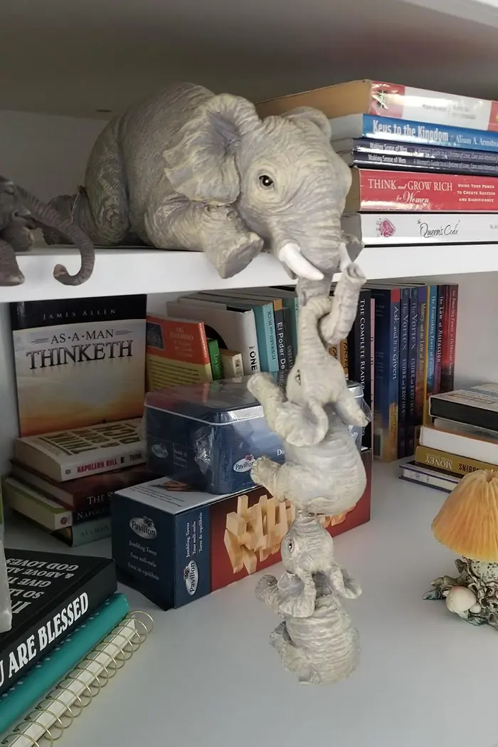 mother elephant with hanging baby elephants bookend statue